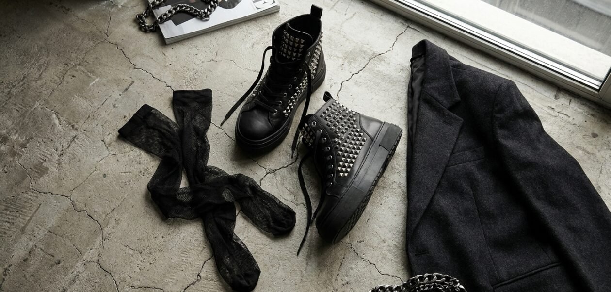 Beast fashion studded high tops open side sneakers laid out with a blazer and mesh socks.